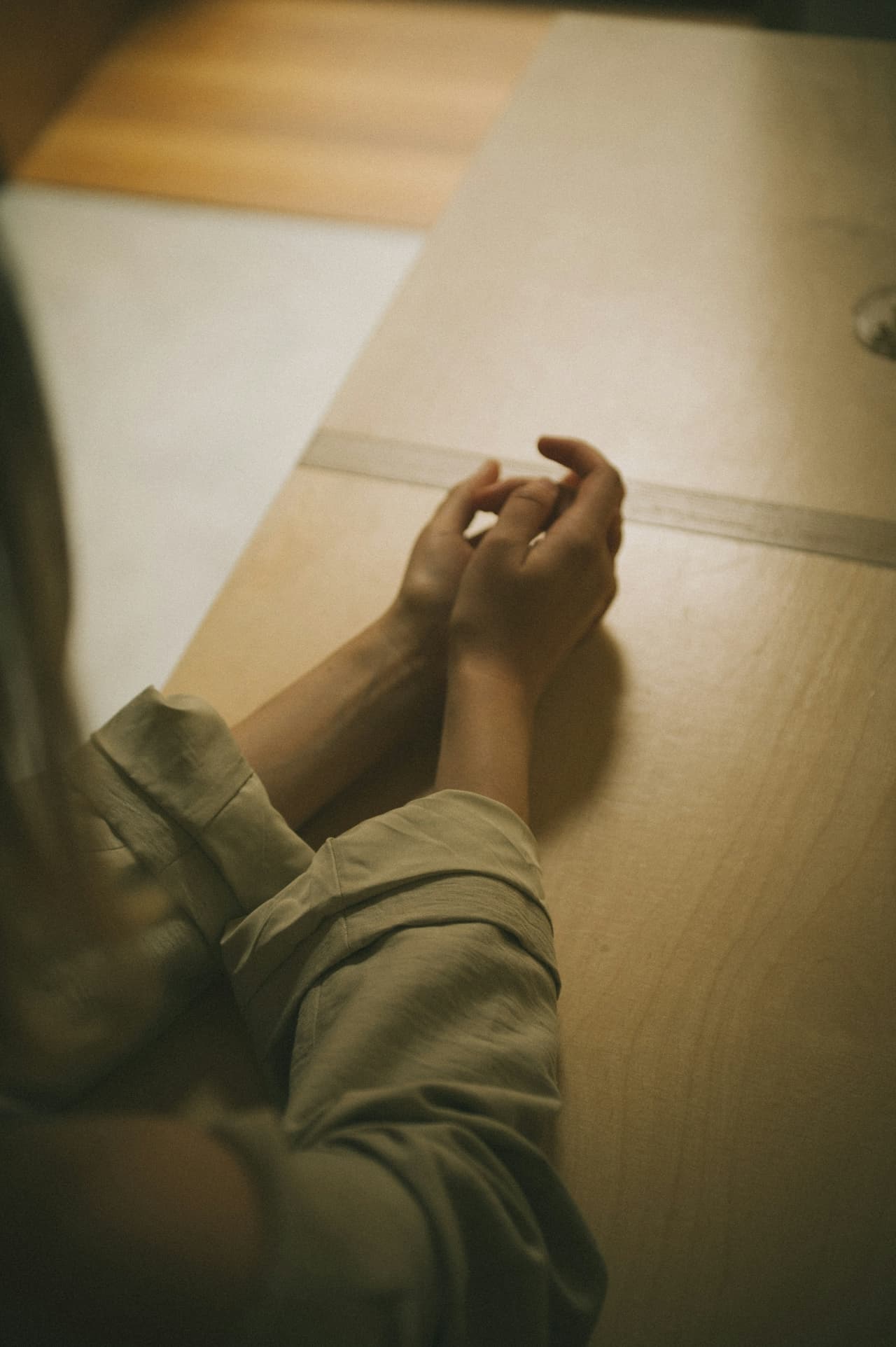 Clasped hands resting on a desk in a calm consultation